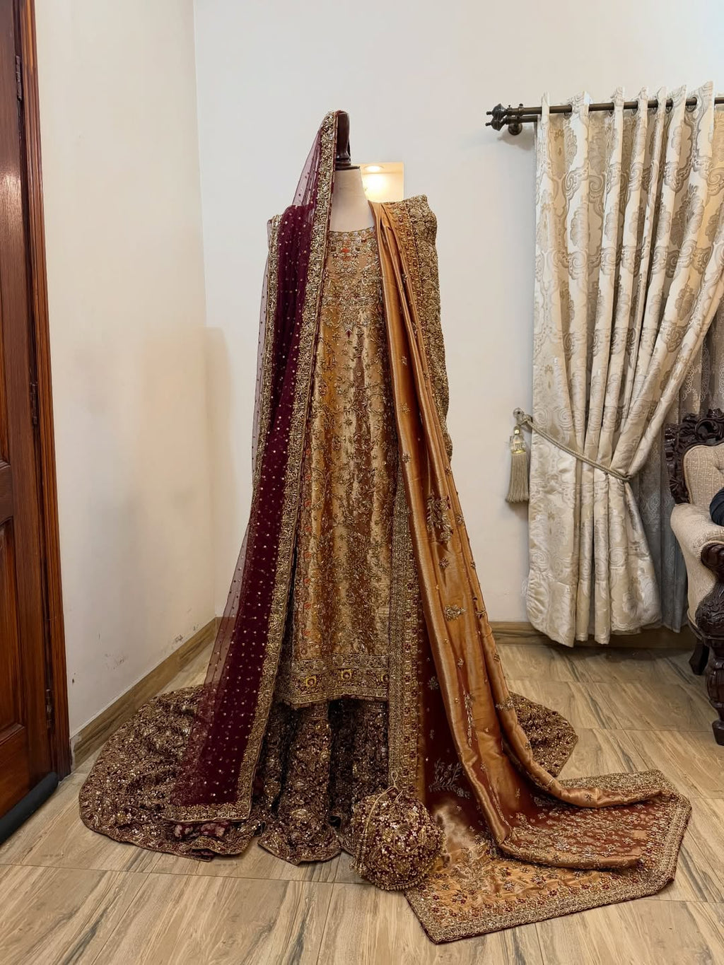 Front view of antique gold bridal dress with dense embroidery and maroon dupatta on mannequin - Èlaan Studio bridal couture