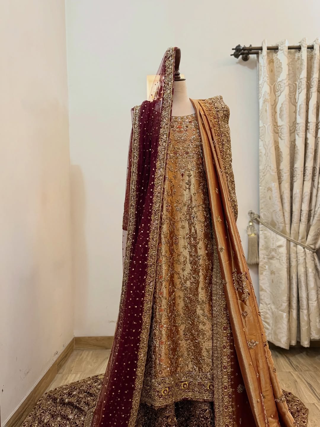 Front view of antique gold bridal dress with dense embroidery and maroon dupatta on mannequin - Èlaan Studio bridal couture