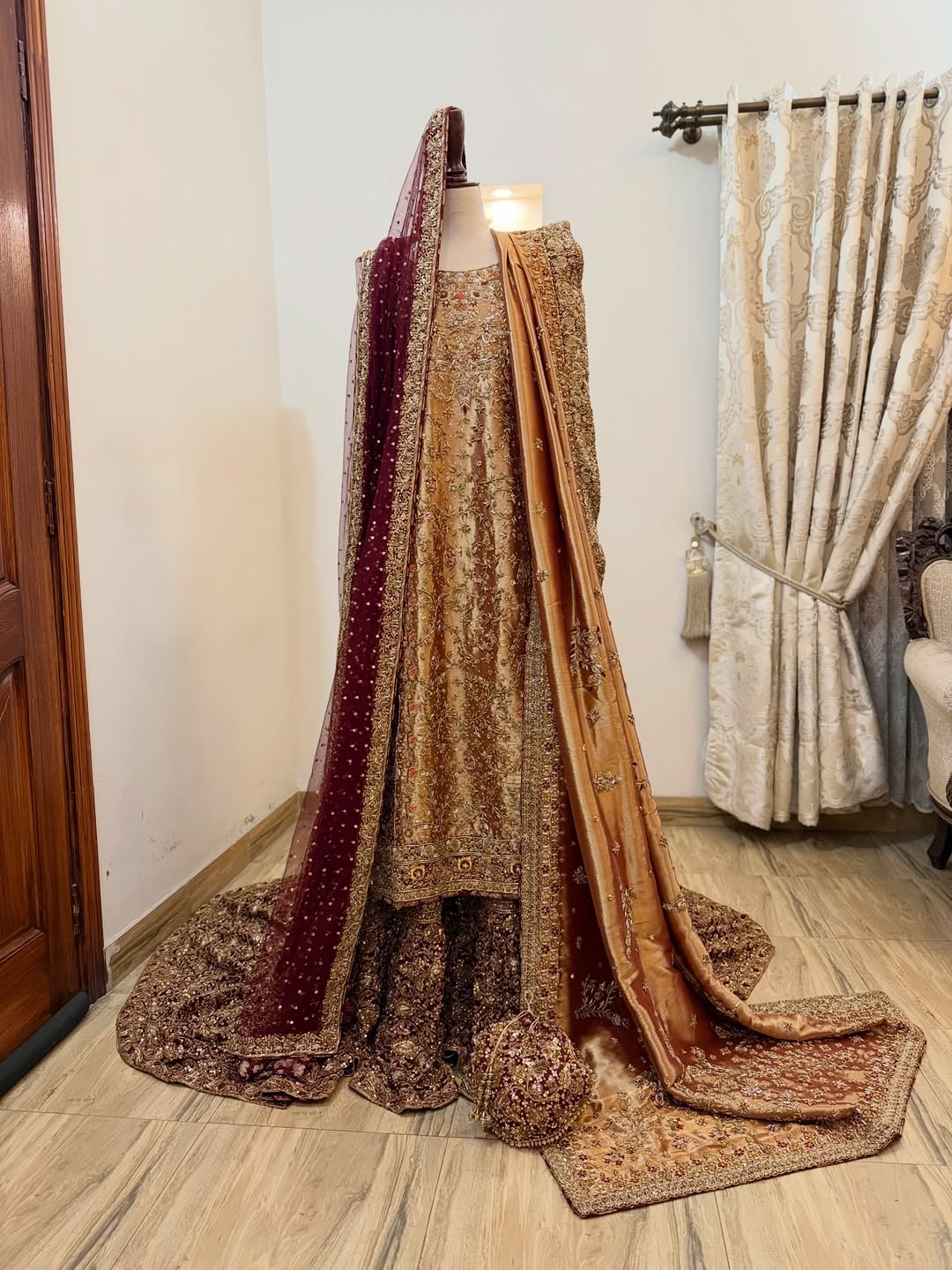 Front view of antique gold bridal dress with dense embroidery and maroon dupatta on mannequin - Èlaan Studio bridal couture