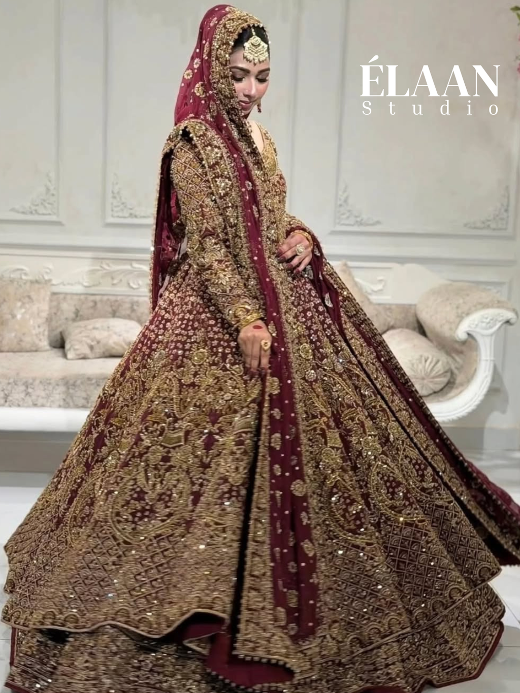 Close view of bride in maroon gold bridal gown showing dense zardozi embroidery and draped dupatta - Èlaan Studio Pakistani wedding wear
