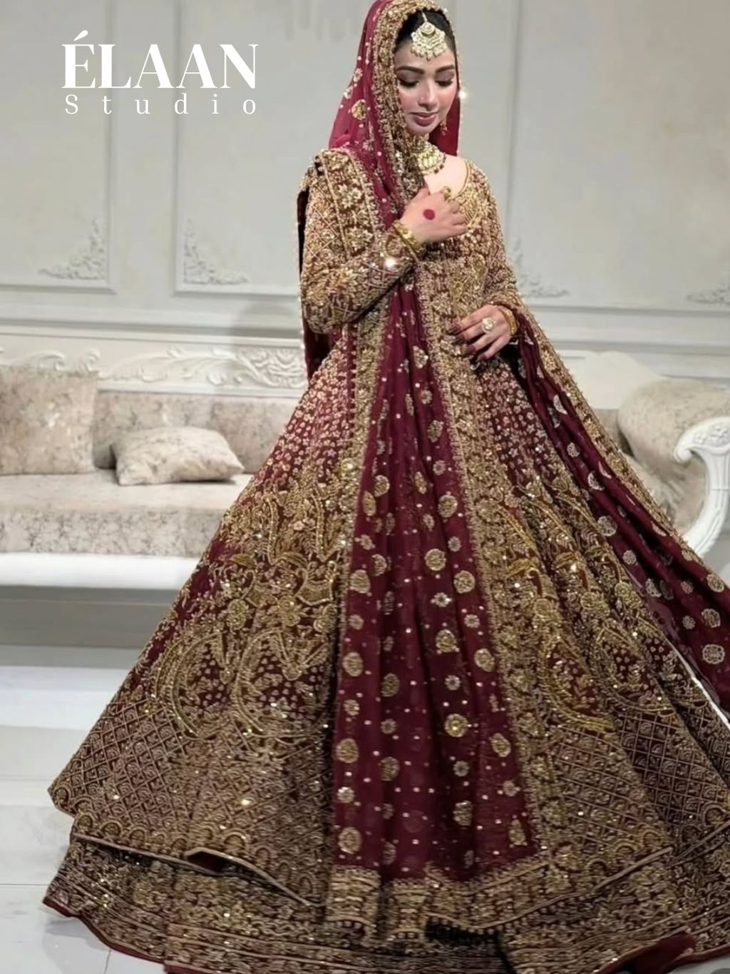Bride in maroon gold embellished bridal gown holding matching embroidered potli bag - Èlaan Studio bridal couture