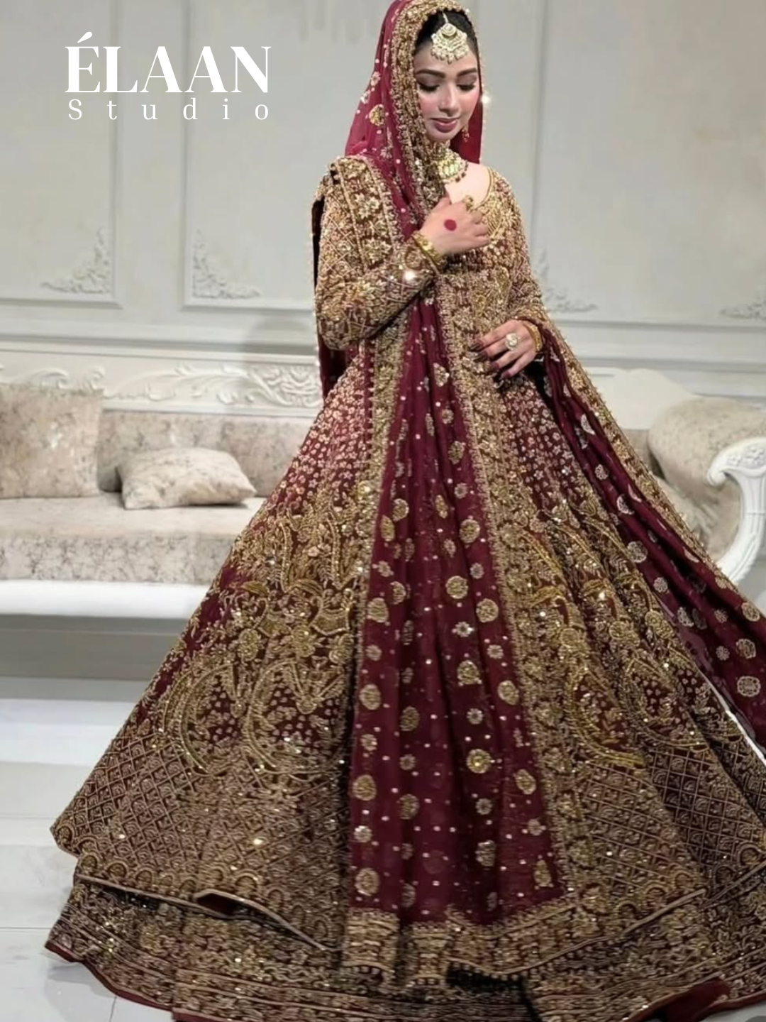 Bride in maroon gold embellished bridal gown holding matching embroidered potli bag - Èlaan Studio bridal couture