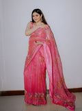 Model wearing pink organza saree with scattered sequin floral embroidery, standing against plain wall - Èlaan Studio party wear