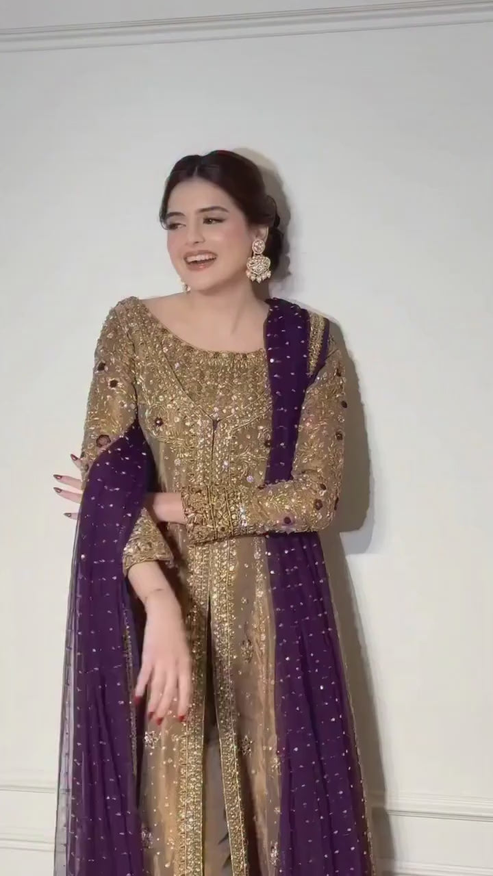 Model in gold embellished suit with purple dupatta standing against wall paneling - Èlaan Studio formal wear